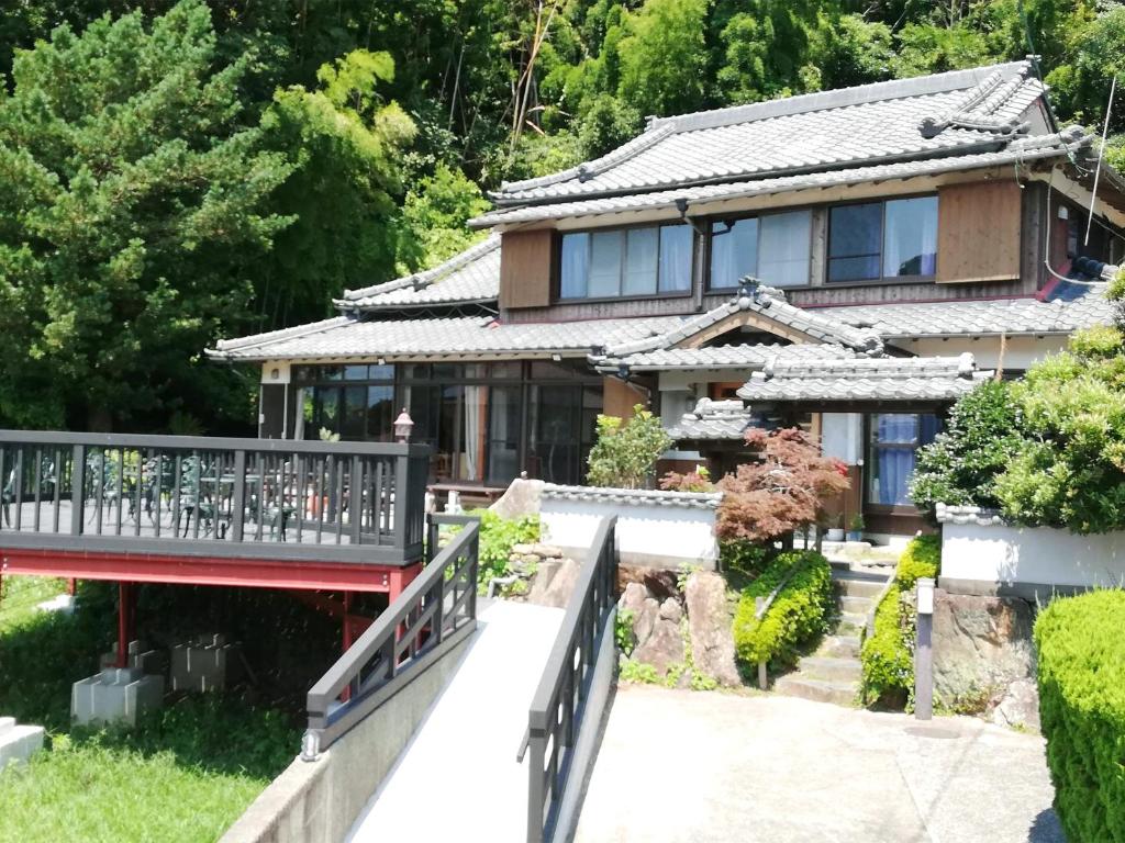 a house with a bridge in front of it at Yukinoura Guest House Moritaya in Saikai
