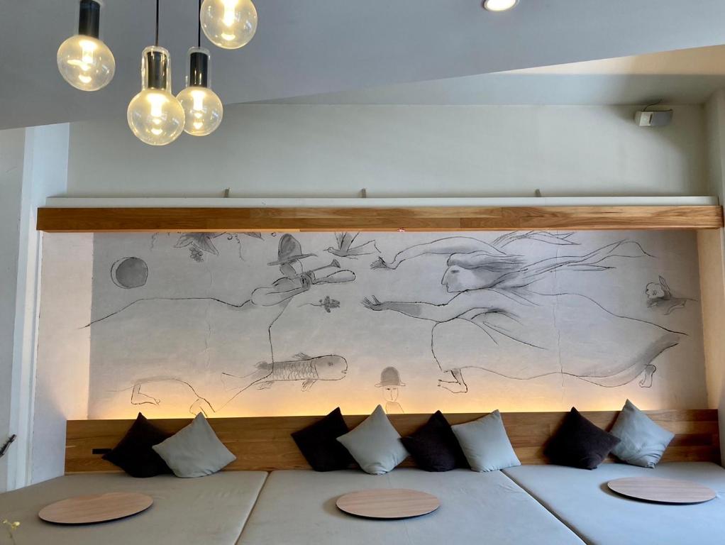 a drawing on the wall above a bed with pillows at Santiago Guesthouse Kyoto in Kyoto