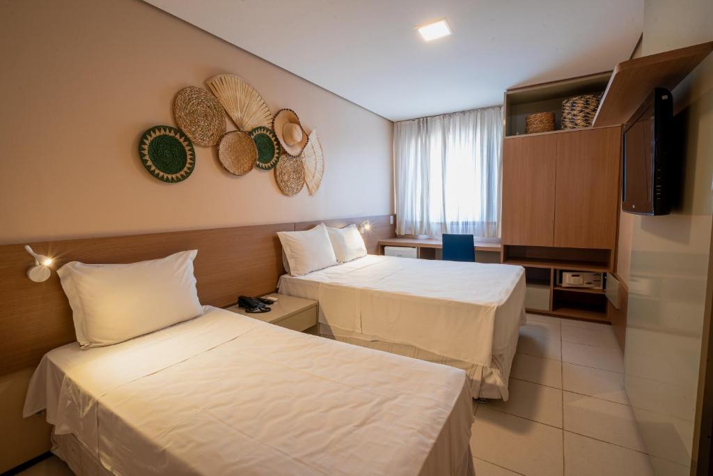 Habitación de hotel con 2 camas y TV de pantalla plana. en Fortaleza Mar Hotel, en Fortaleza