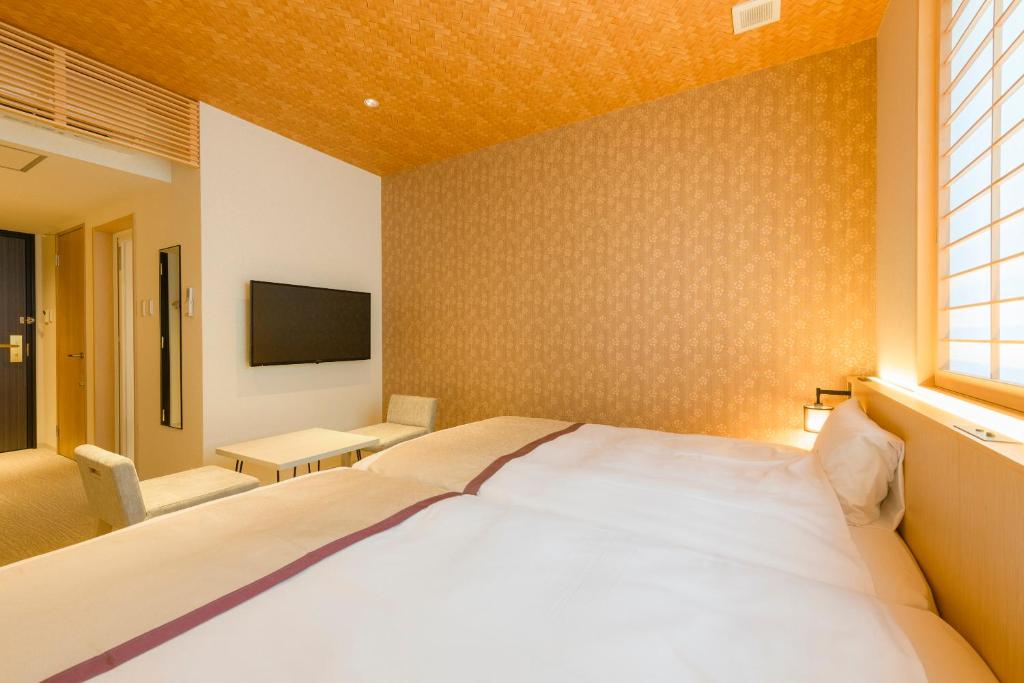 a bedroom with a large bed and a tv at Tosei Hotel Cocone Kamakura in Kamakura