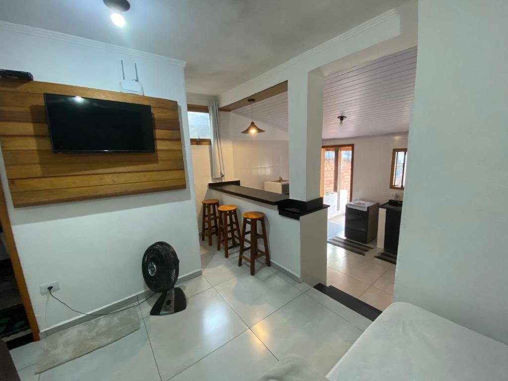 a living room with a tv on a wall at Chalé Aconchego 1 in Ilhabela