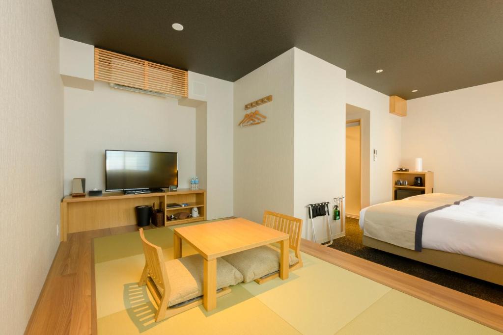 a bedroom with a bed and a table and a television at Tosei Hotel Cocone Kamakura in Kamakura