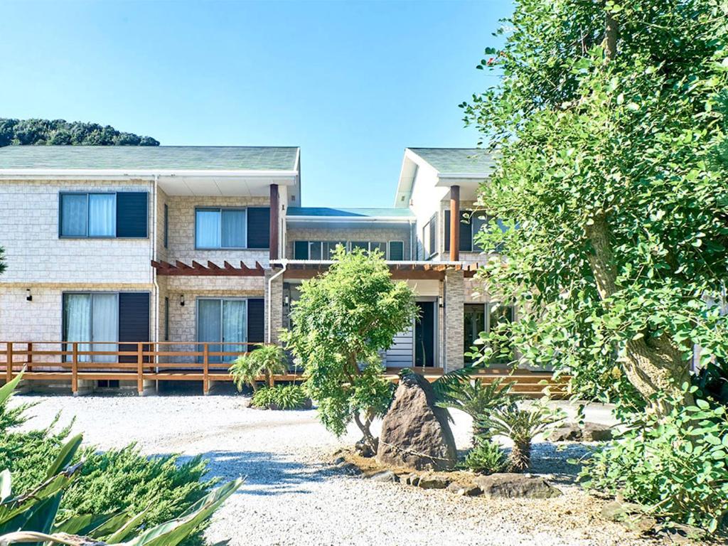a large house with a tree in front of it at Mantenbo in Hachijo