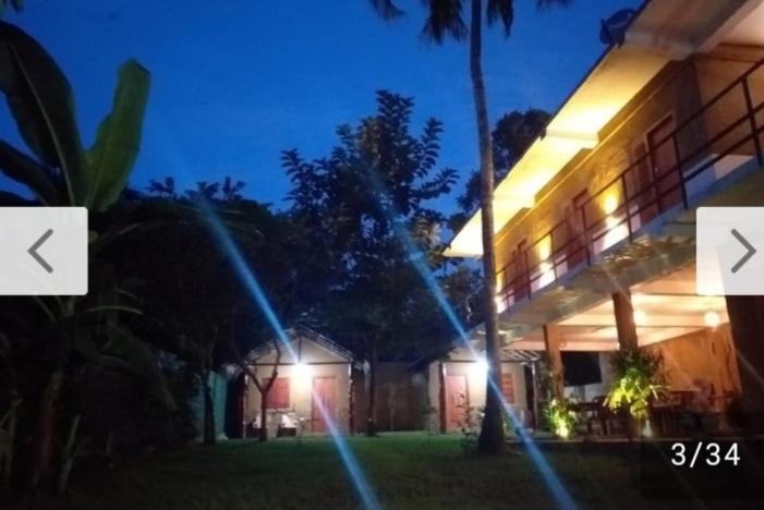 a building with lights on the side of it at night at Nature lovers safari House in Udawalawe