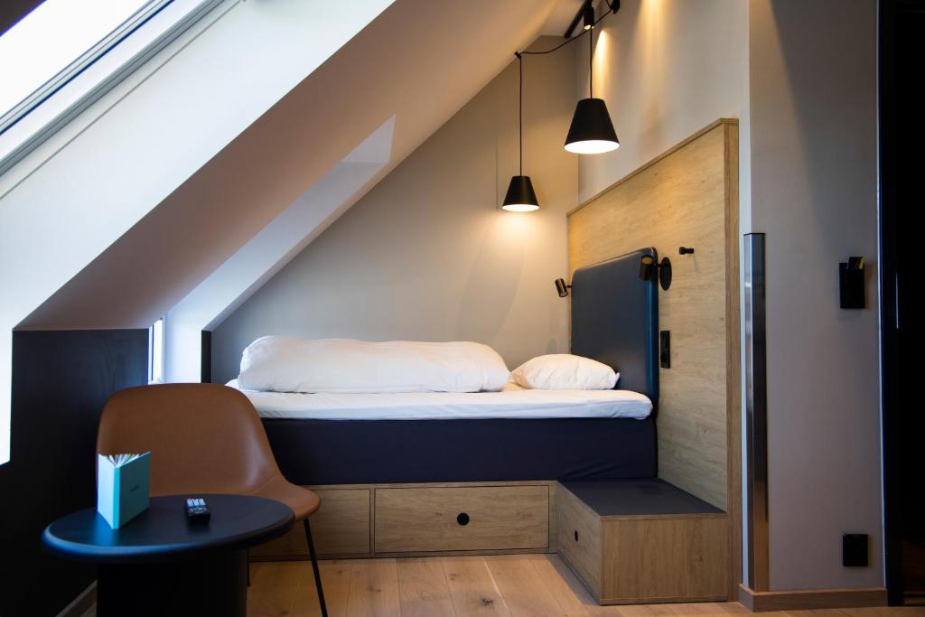 a small room with a bed in the attic at Comfort Hotel Xpress Youngstorget in Oslo