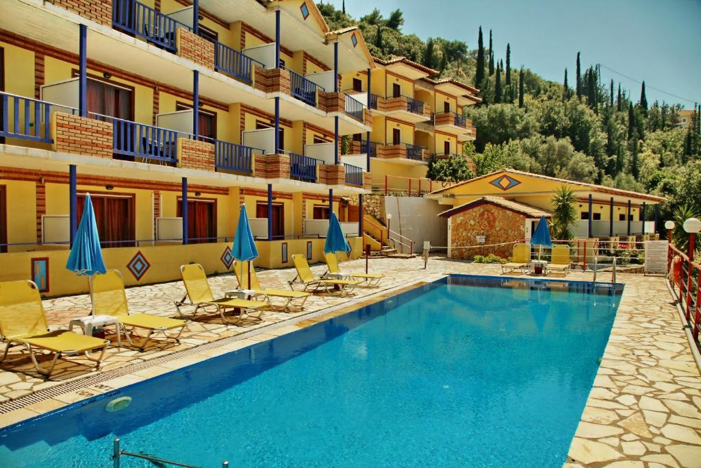 a hotel with a swimming pool in front of a building at Politia Hotel in Agios Nikitas