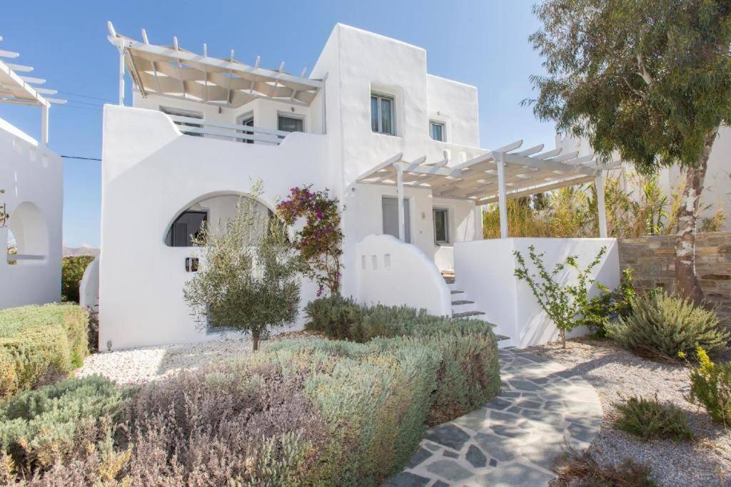 una casa blanca con un jardín delante de ella en Magganari Home Stelida Naxos en Agios Prokopios