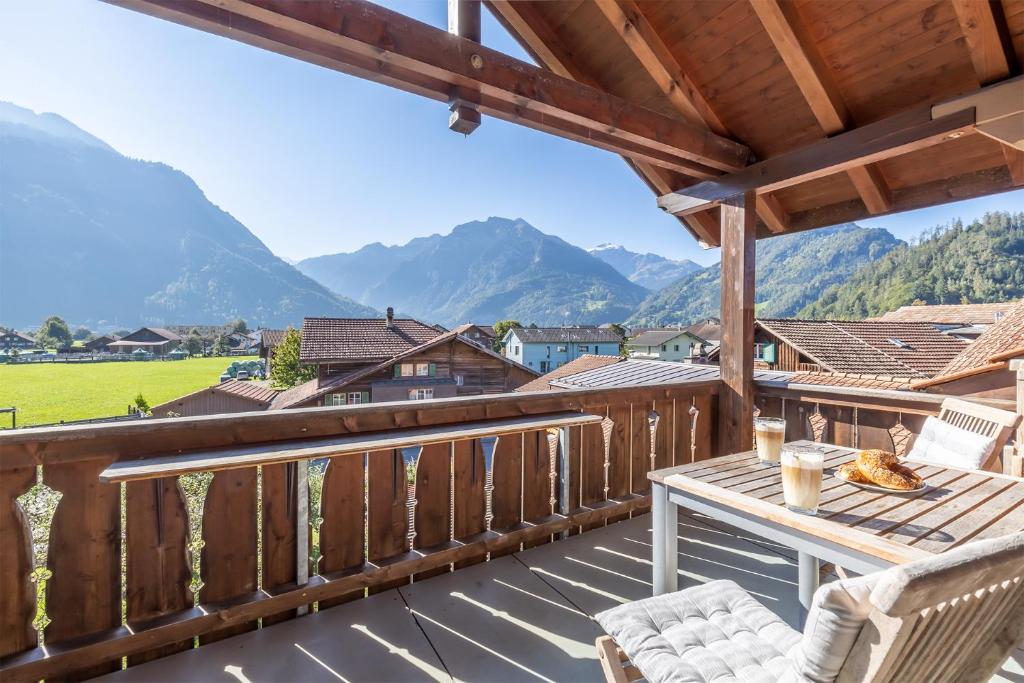 a balcony with a table and chairs and mountains at Mohn in Interlaken