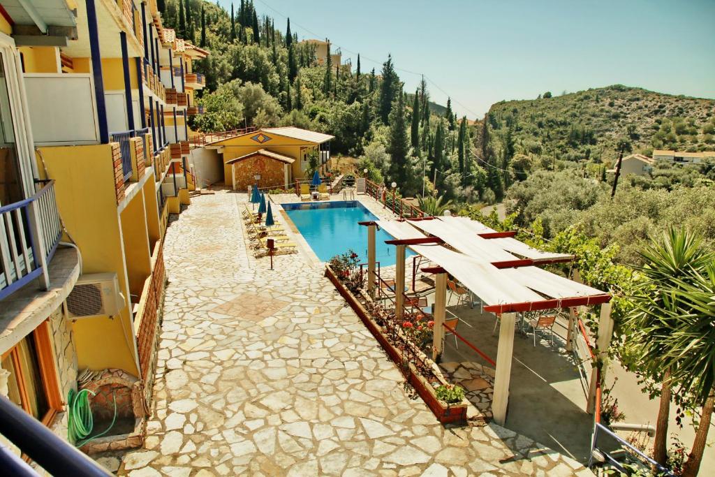 an outdoor swimming pool with a view of a mountain at Politia Hotel in Agios Nikitas