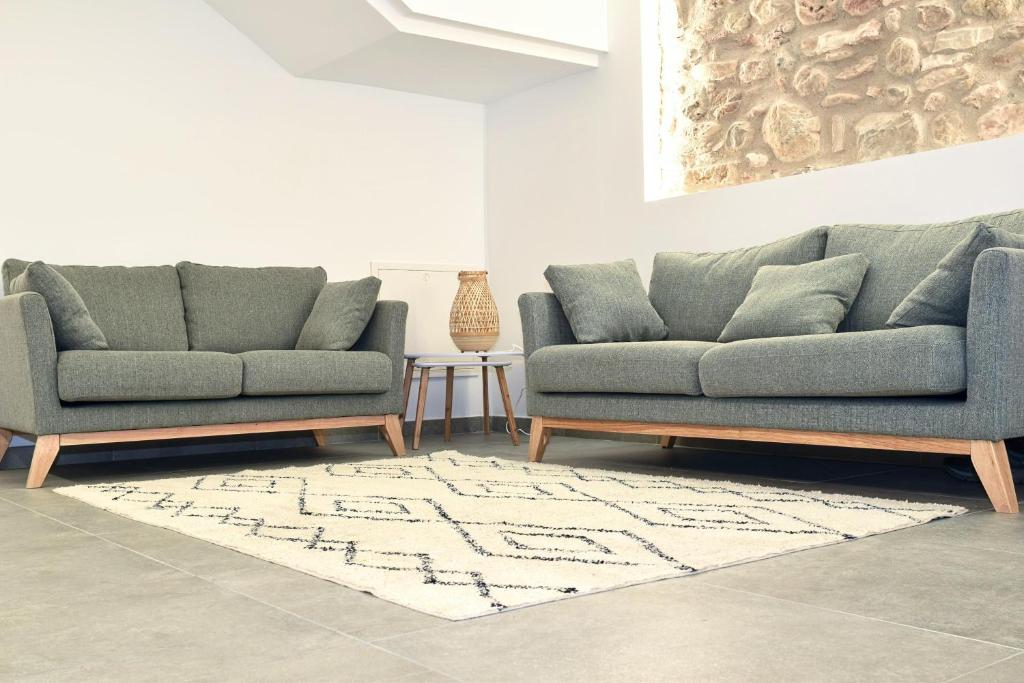 uma sala de estar com dois sofás e um tapete em Casa Rural Cal Saboner em Les Coves de Vinroma