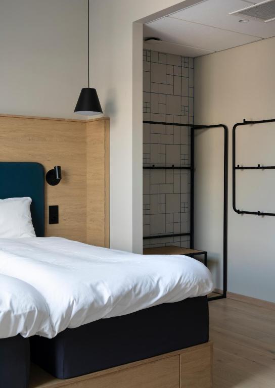 a bedroom with a large bed with white sheets at Comfort Hotel Xpress Youngstorget in Oslo