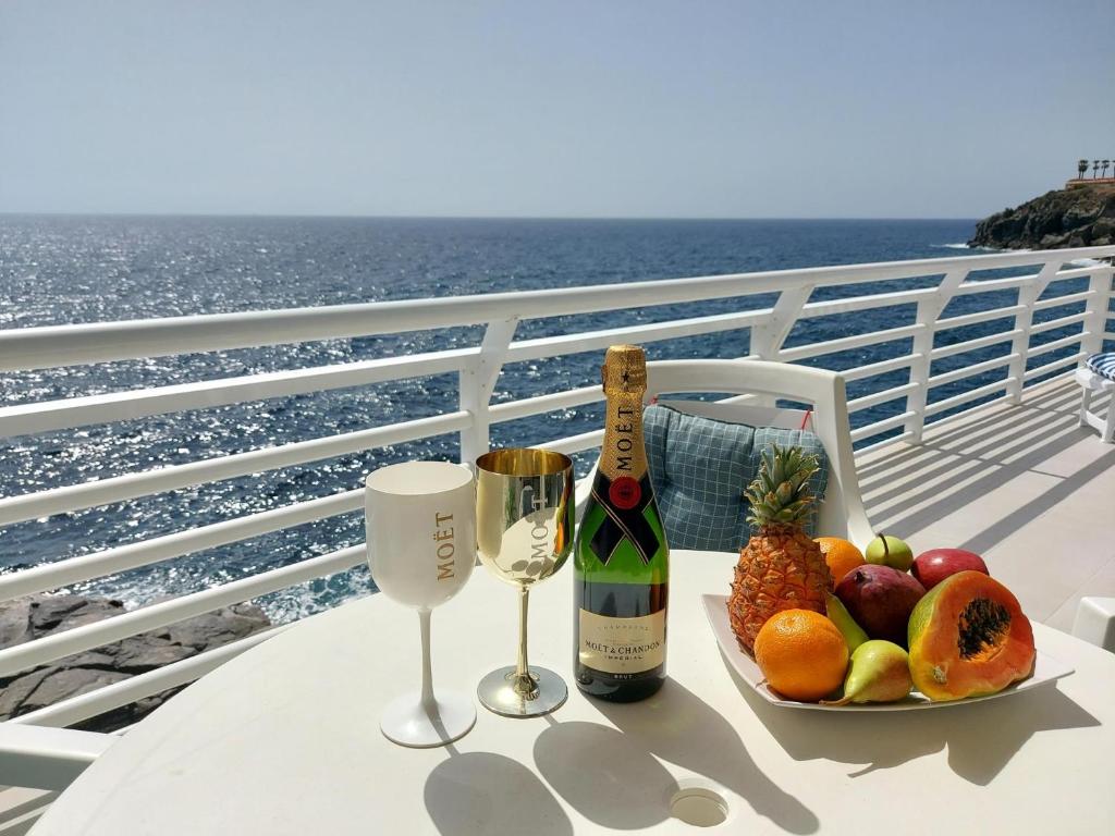 een tafel met een fruitschaal en een fles wijn bij Love boat deluxe experience in Callao Salvaje