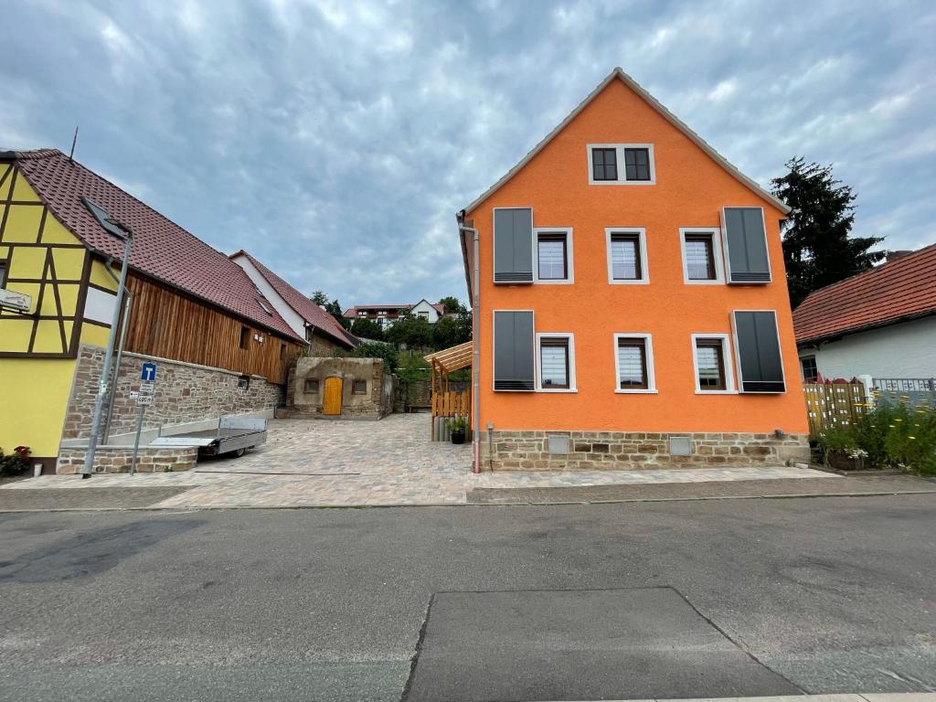 Ein orangefarbenes Haus liegt an der Seite einer Straße in der Unterkunft Haus 13 zum Südblick in Garnbach