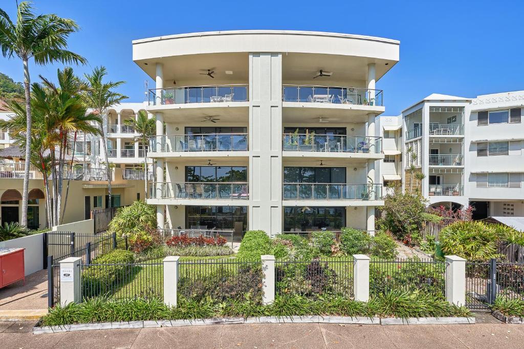 un gran edificio de apartamentos con una valla delante en Meridien Beachfront Apartments at Trinity Beach en Trinity Beach