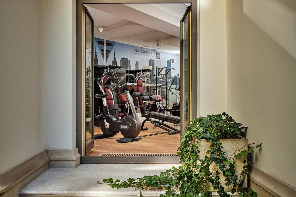 a mirror in front of a gym with exercise equipment at H15 Boutique Hotel, Warsaw, a Member of Design Hotels in Warsaw