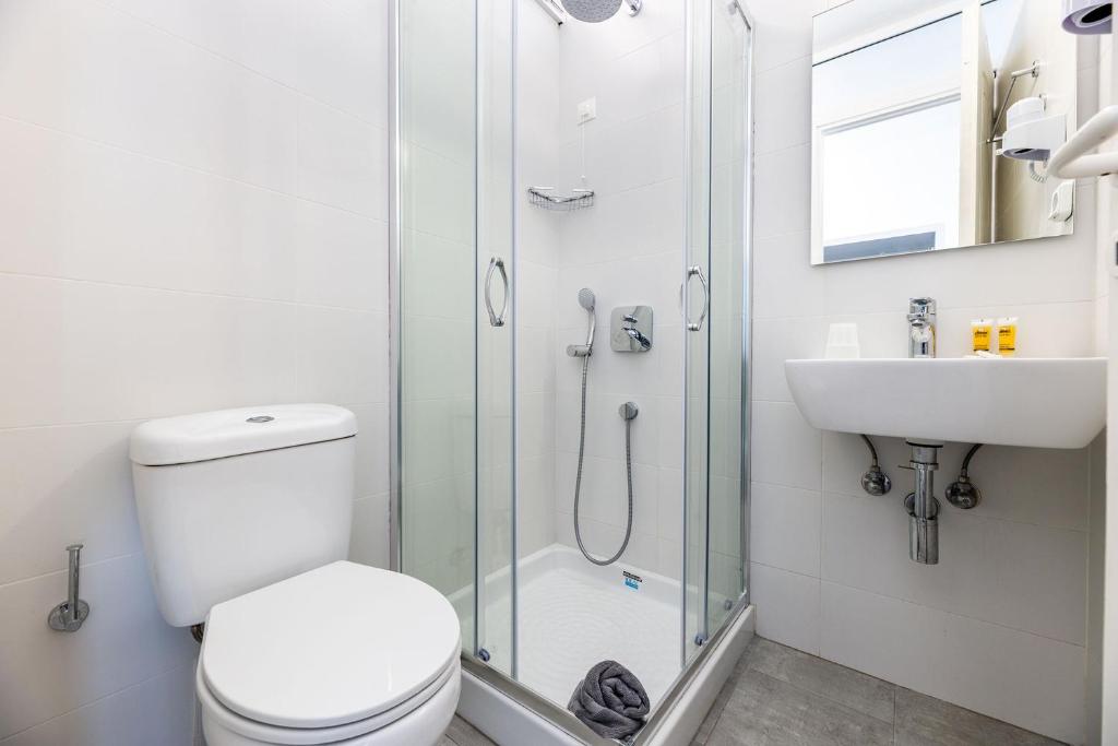 a bathroom with a shower and a toilet and a sink at Hippocampus Hotel in Naousa