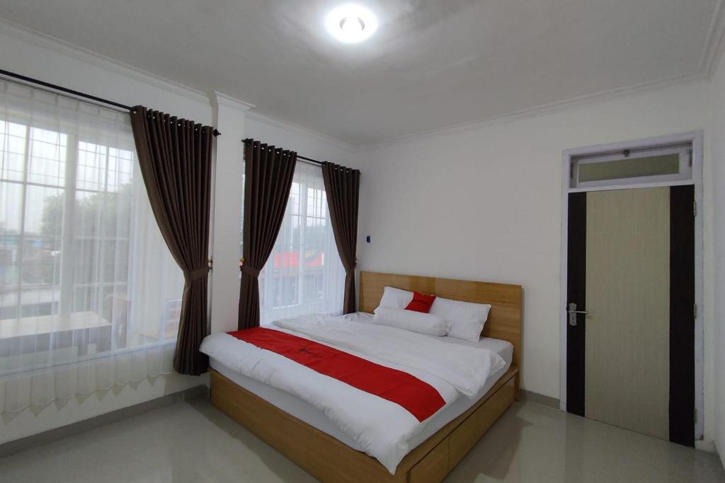 um quarto com uma cama grande e uma janela em RedDoorz near Rita Super Mall Purwokerto em Purwokerto