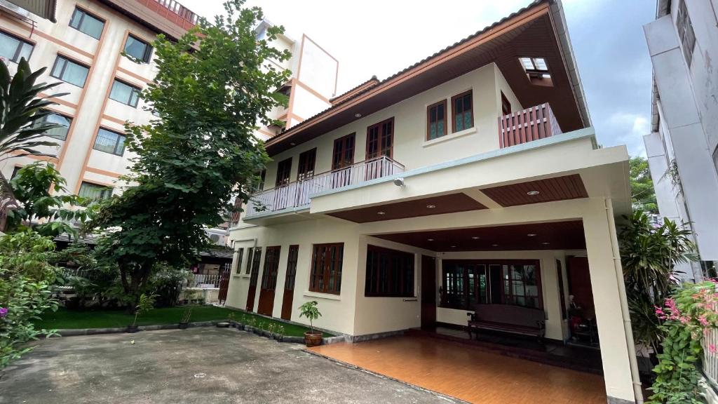 uma casa com um pátio em frente a um edifício em Chan Home Villa em Bangkok