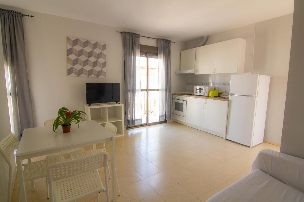 a kitchen with a table and a white refrigerator at Apartamento Jerez in Jerez de la Frontera