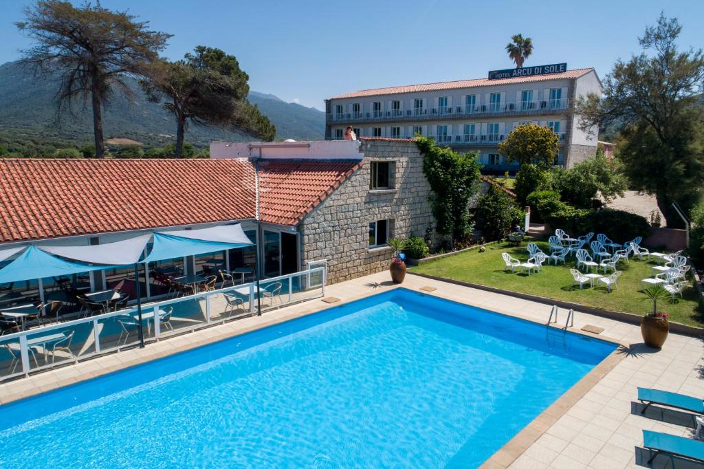 een villa met een zwembad en een gebouw bij Hotel Arcu Di Sole in Propriano