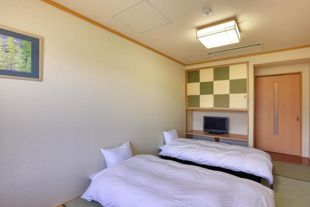 Postel nebo postele na pokoji v ubytování Fuji Matsuzono Hotel