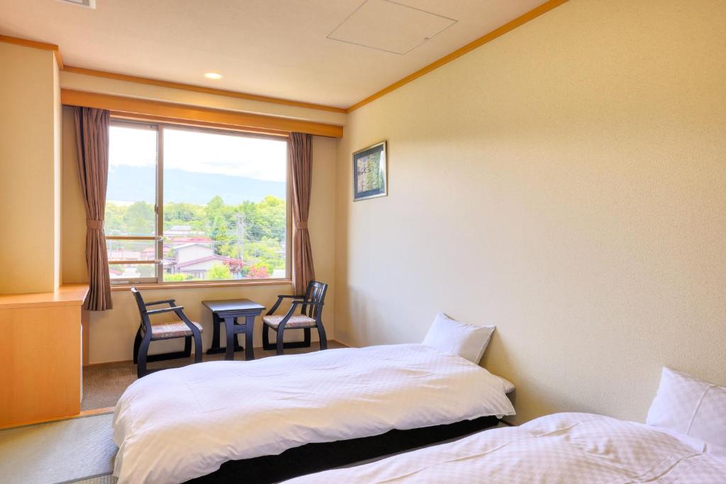 Postel nebo postele na pokoji v ubytování Fuji Matsuzono Hotel