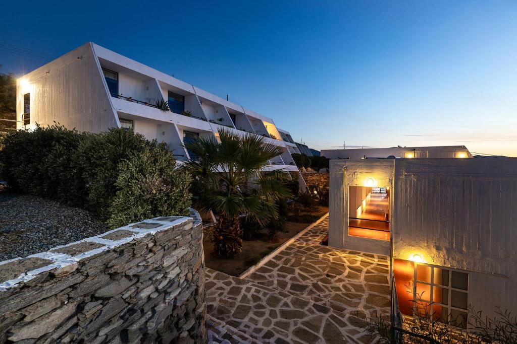 a building with a stone wall next to a building at Hippocampus Hotel in Naousa