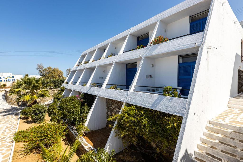 an apartment building with white balconies and plants at Hippocampus Hotel in Naousa