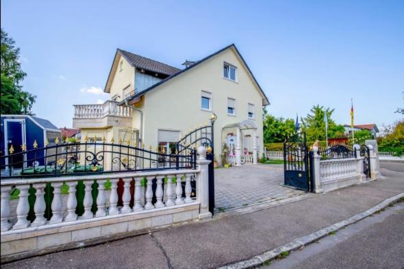 a white house with a fence in front of it at Villa Prince, für Handwerker auch langfristig, nähe Ingolstadt in Vohburg an der Donau