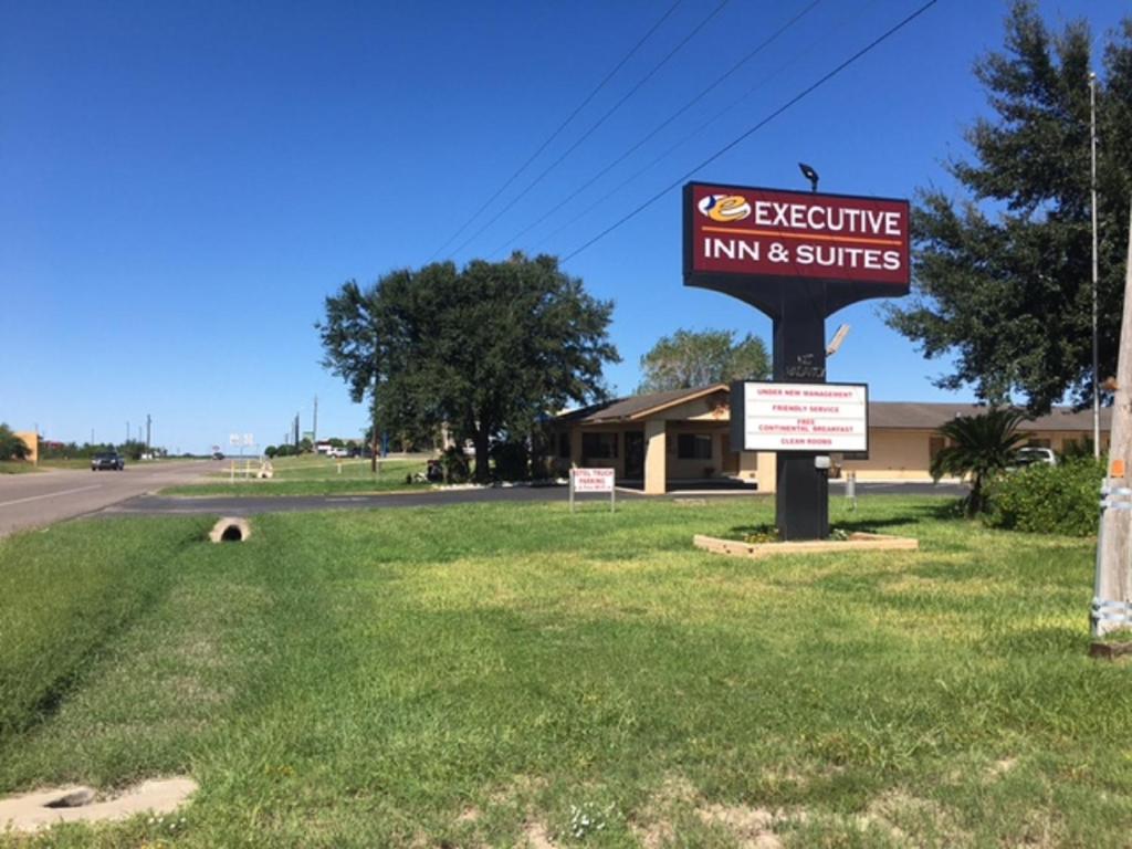 a sign for an inn and suites on the side of a road at Hebbronville Executive Inn in Hebbronville