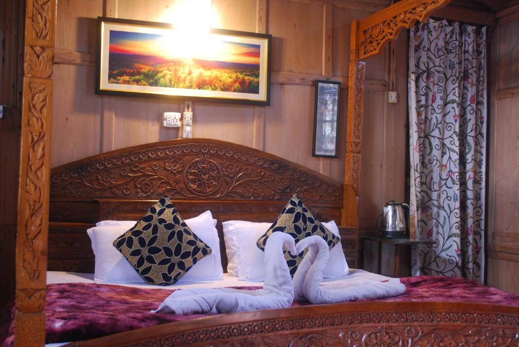 1 dormitorio con cama de madera y almohadas en Young Shahzada Group of Houseboats, en Srinagar