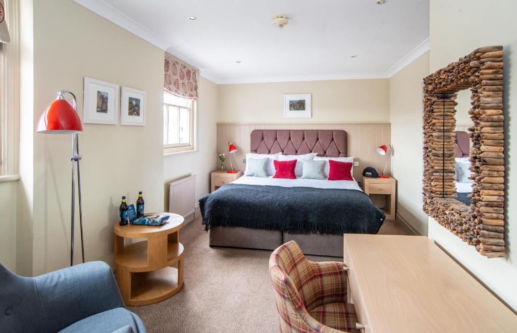 a bedroom with a bed and a living room at Crown Hotel in Southwold