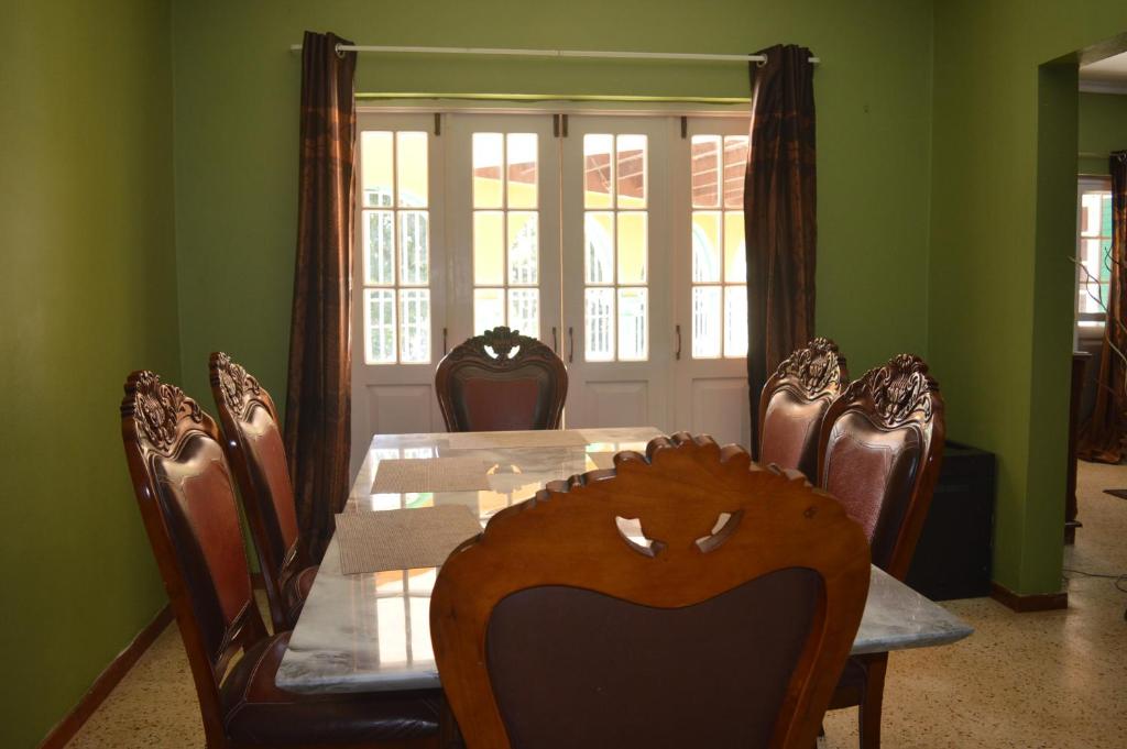 a dining room with a table and chairs and a window at Stunning 3-Bedroom house in Ocho Rios Upton in Ocho Rios