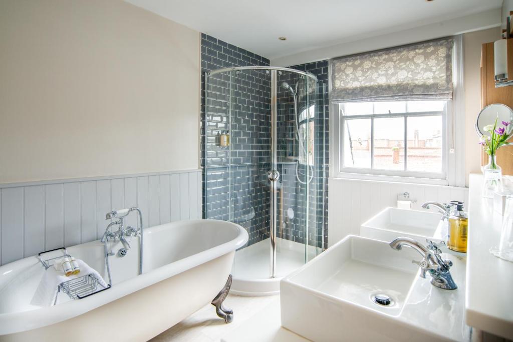 a bathroom with a tub and a sink at Crown Hotel in Southwold