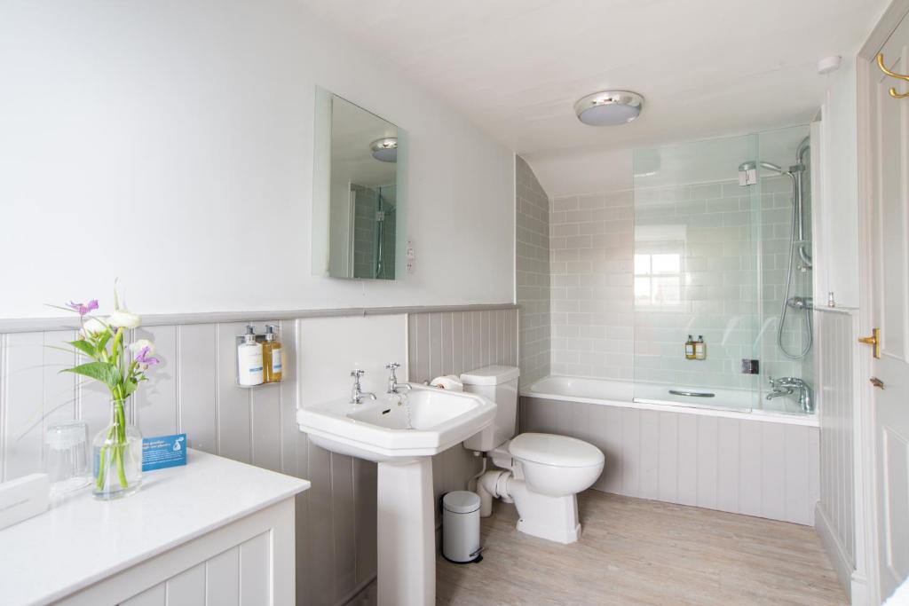 a white bathroom with a sink and a toilet at Crown Hotel in Southwold