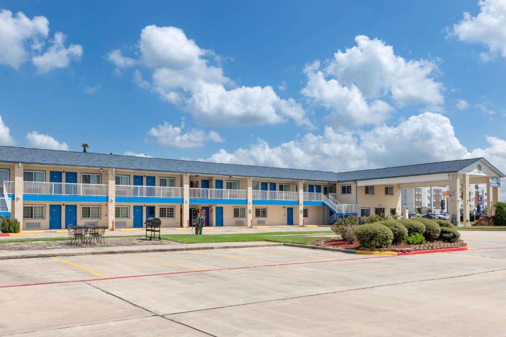 an empty parking lot in front of a building at Days Inn by Wyndham Baytown TX in Baytown