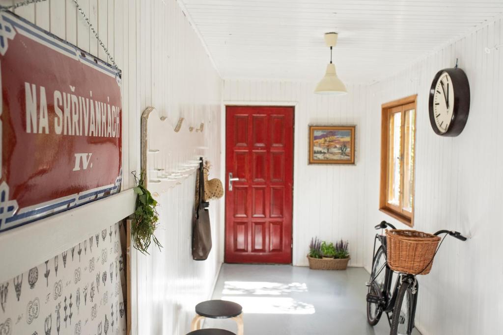 una porta rossa in un corridoio con una bicicletta in una stanza di Apartman Astrum a Poprad
