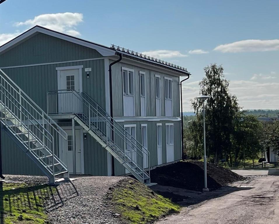 un bâtiment vert avec des escaliers sur son côté dans l'établissement Frost Longstay Egnahemsvägen, à Kiruna