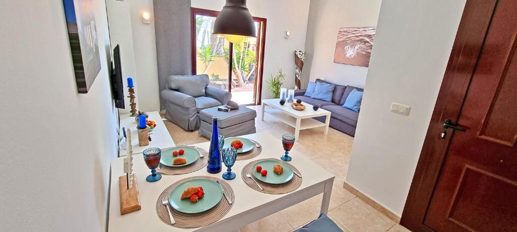 a living room with a table with plates of fruit on it at Ferienhaus CASA MAJA Costa Calma Meerblick Garten in Costa Calma