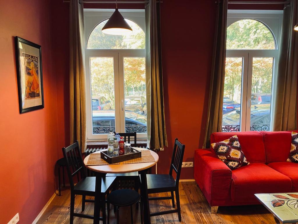 a living room with a red couch and a table at La Duchesse d'Aumale in Spa