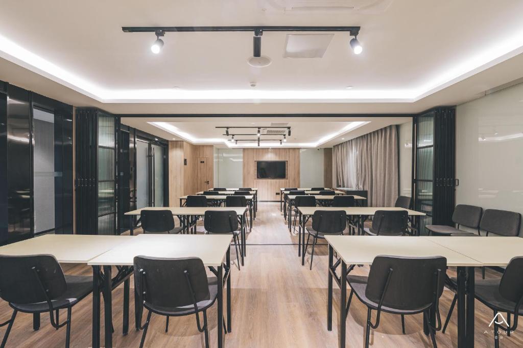 a conference room with tables and chairs and a podium at Atour Light Nanjing Xinjiekou NetEase CloudMusic in Nanjing
