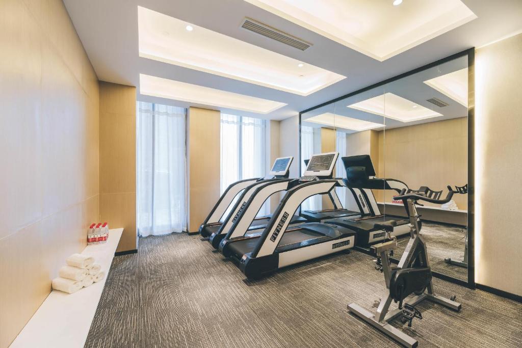 sala de fitness con cinta de correr y espejo en Atour Hotel Kunshan Yongda Business Plaza en Kunshan