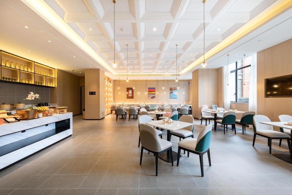 a dining room with tables and chairs in a restaurant at Atour Hotel Ningbo Fenghua Huizheng Street in Ningbo