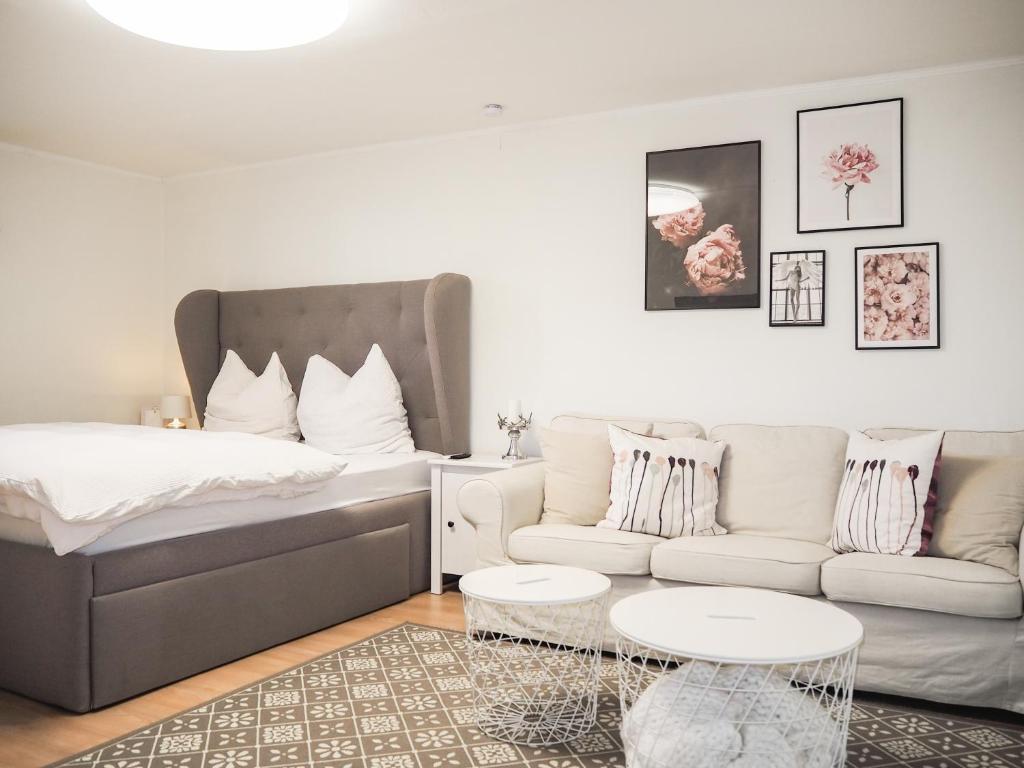 a living room with a bed and a couch at Stylische Wohnung in ruhiger Lage, sehr messenah in Laatzen