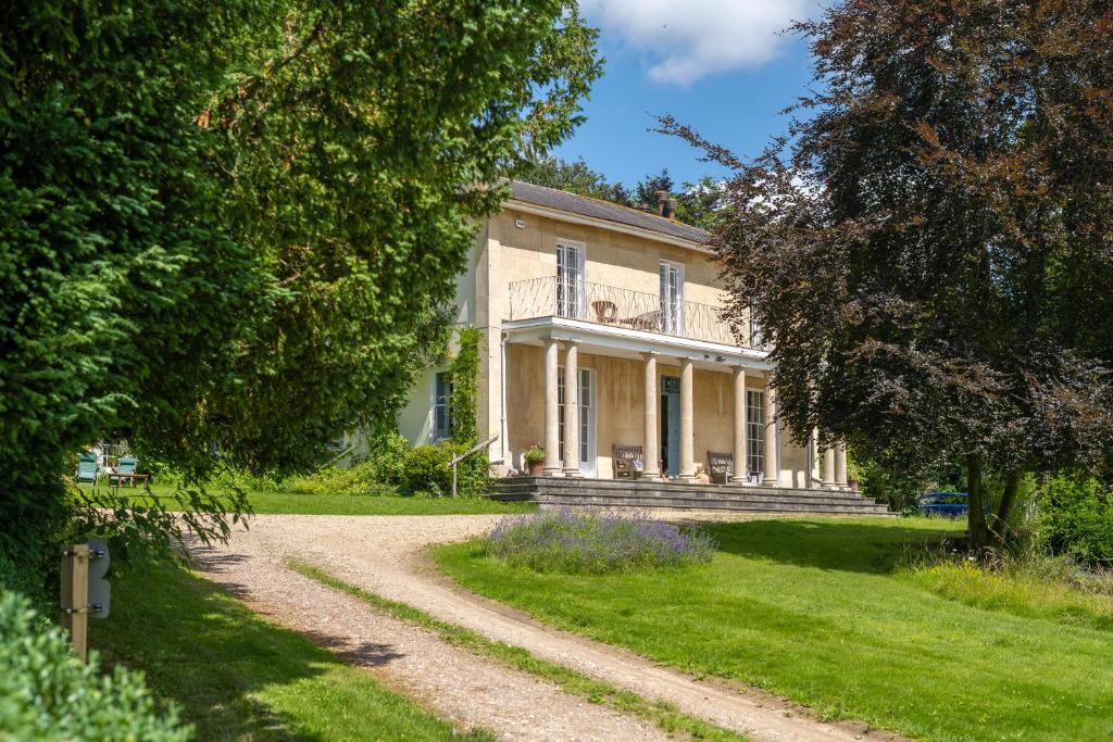 una casa con un camino de tierra delante de ella en Henge Estate - Restored Manor House, up to 11 en-suite bedrooms, en Shrewton