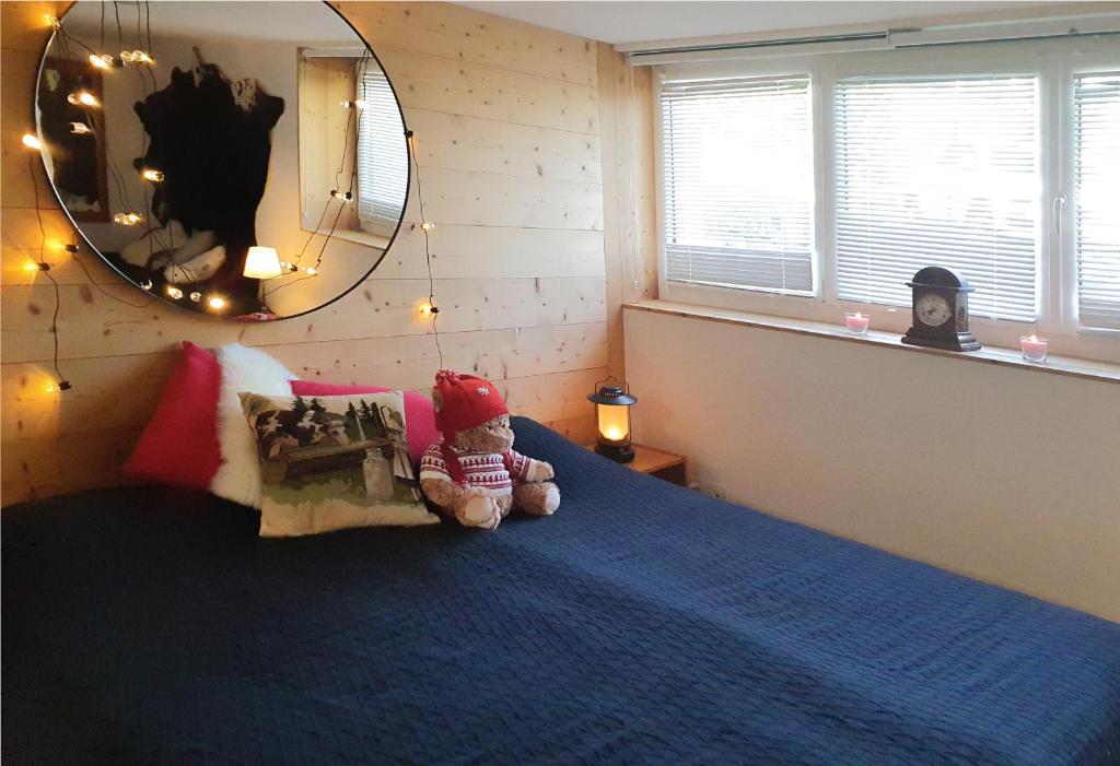 um urso de peluche sentado numa cama num quarto em Nérine em Leysin