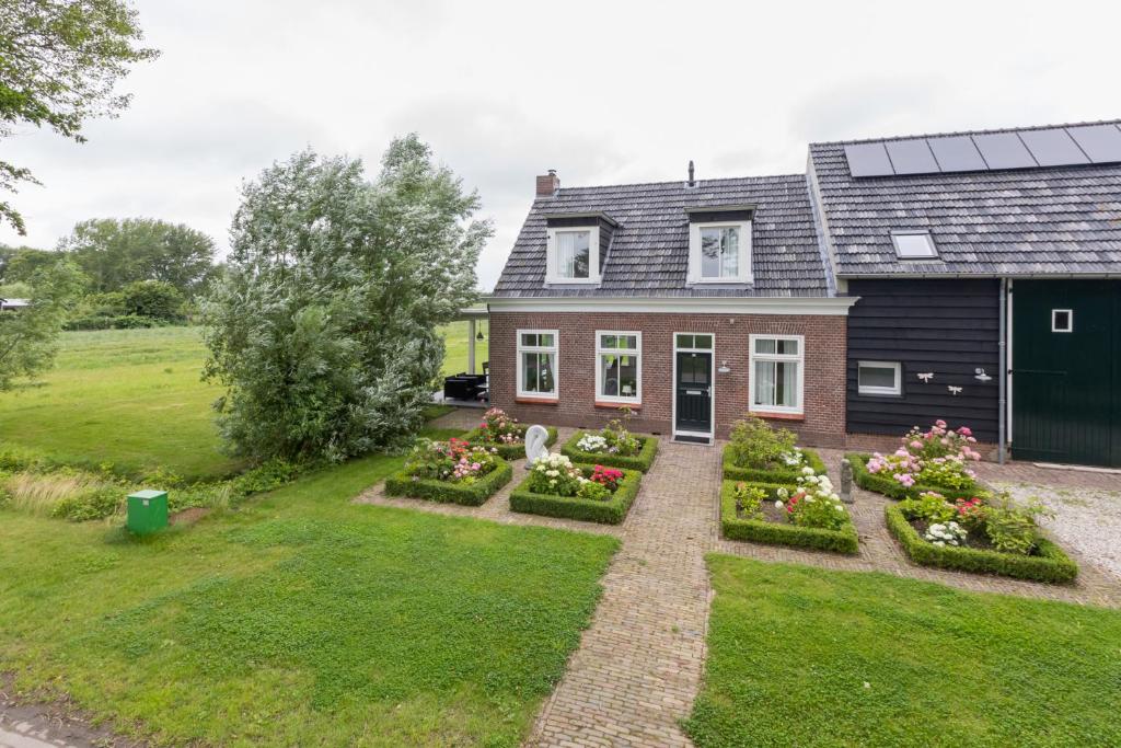 una casa con un jardín delante de ella en Lepelstraat 14, Vrouwenpolder- Knotwilg, en Vrouwenpolder
