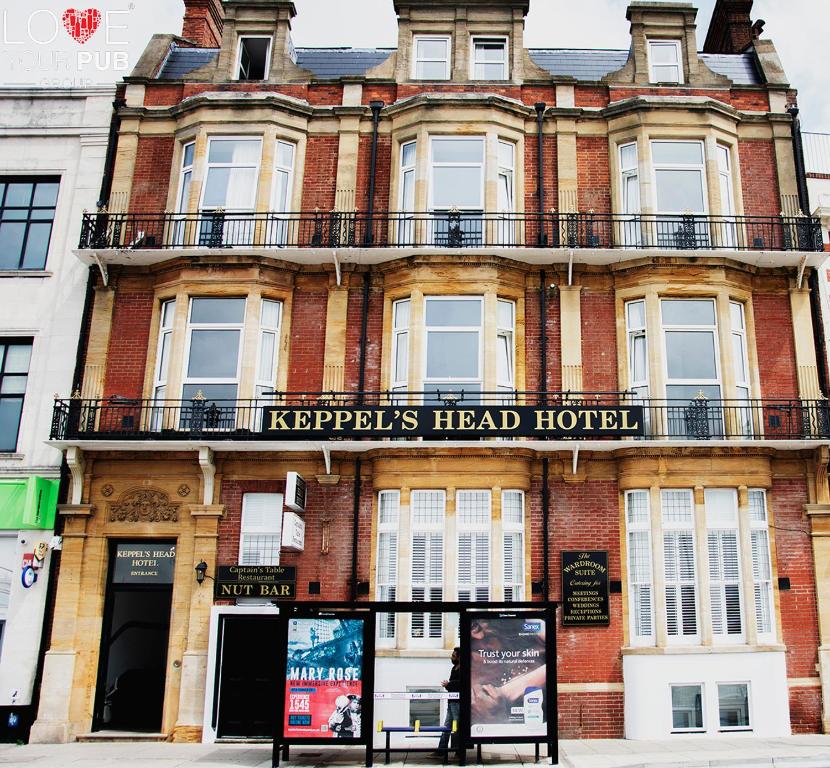 un edificio de ladrillo rojo con un cartel. en Keppels Head Hotel, en Portsmouth