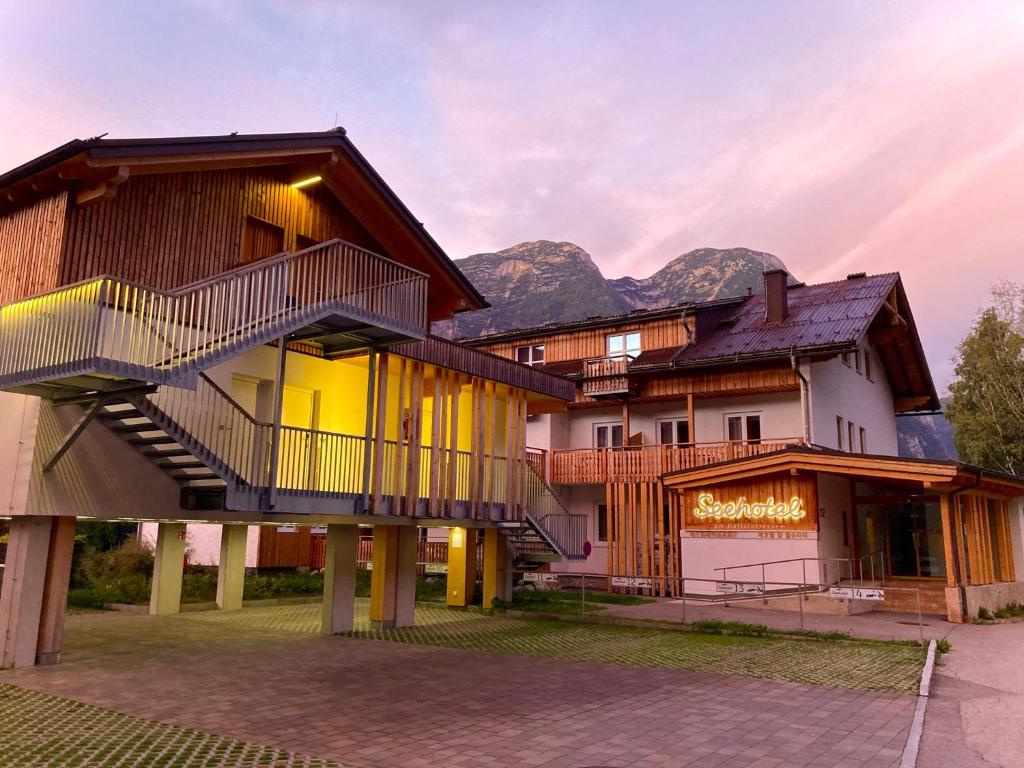 a resort with mountains in the background at Seehotel am Hallstättersee modern rooms in Obertraun