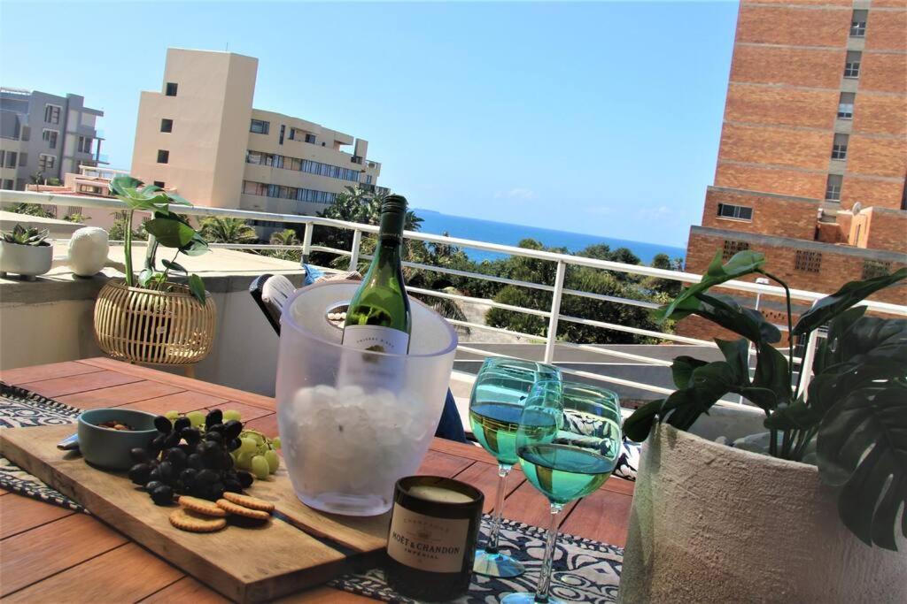 een fles wijn op een tafel met wijnglazen bij Luxury Apartment in Umhlanga Rocks in Durban